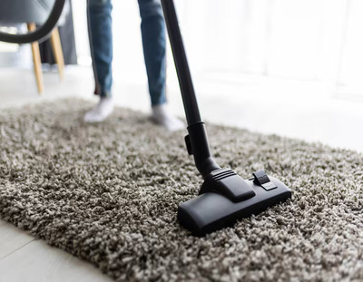 Carpet & Rug Cleaning people housework housekeeping concept close up woman with legs vacuum cleaner cleaning carpet home 231208 13612